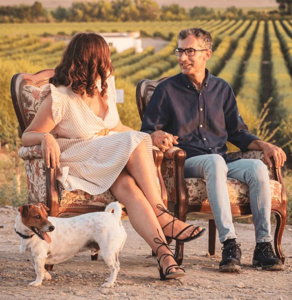 fotos de preboda en viñedos de Córdoba con pareja sentada y su perro al atardecer
