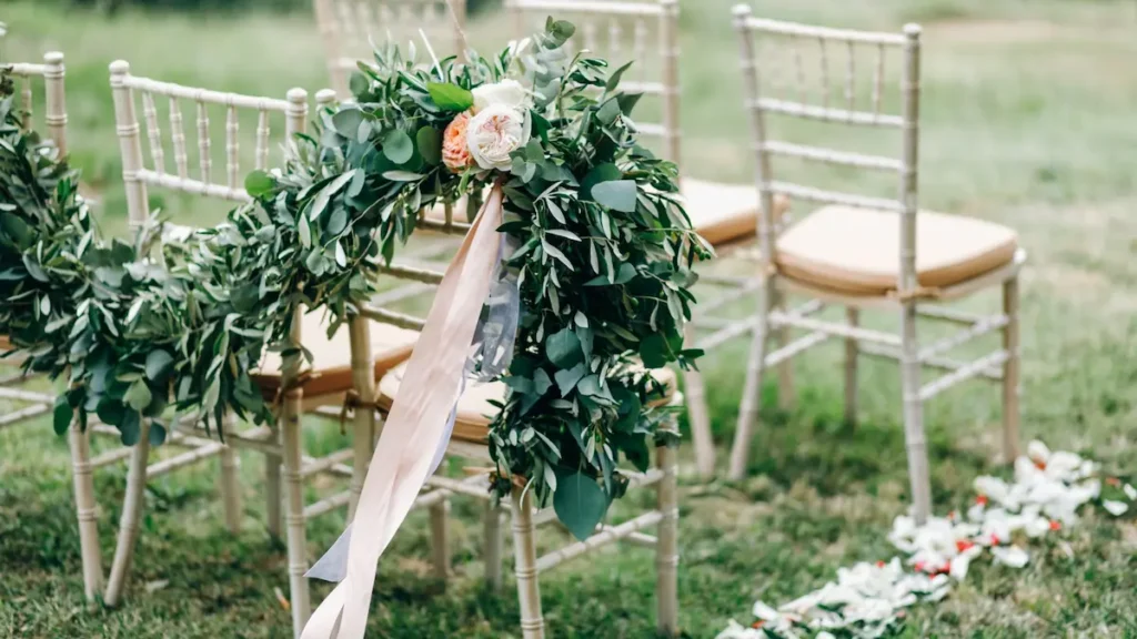 Sillas decoradas con guirnaldas de eucalipto en ceremonia exterior de bodas en Montilla