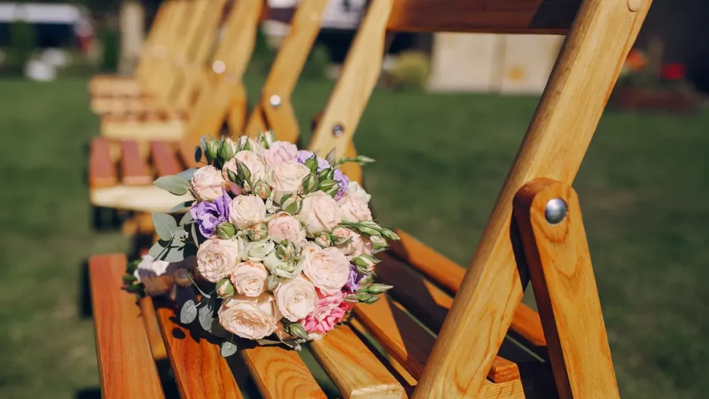 Ramo de novia sobre silla de madera en bodas en Montilla al aire libre con fondo de jardín