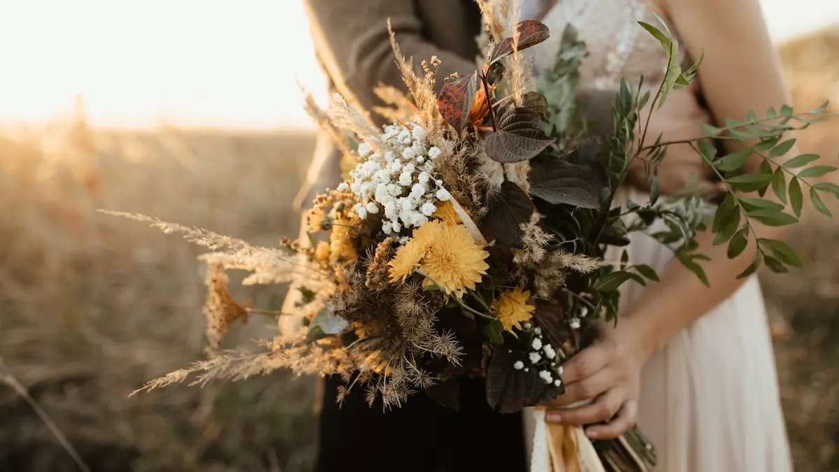 Ramo de flores silvestres al atardecer en bodas en Montilla: pareja en entorno rural con luz dorada