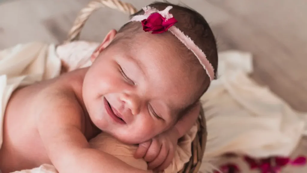 Bebé recién nacida sonriendo durante sesión newborn en estudio en Córdoba